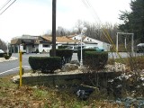 The marker can be found on the concrete wall of the basin just below the grate (behind the garbage bag). That's the Inn in the background.