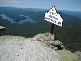 Eyelevel view of the bolt in the rock ledge, with the Whiteface summit sign in background.