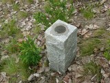 Eyelevel view of the boundary marker disk on granite monument.